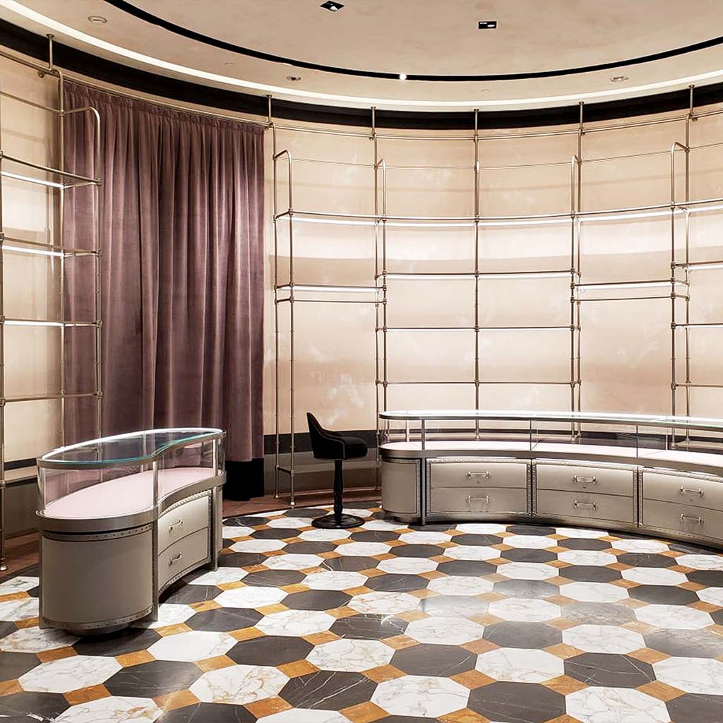 A room of the Gucci Store located in Landmark Hong Kong. The retail design project was designed by Fantetti team. In this space we can find a marble floor and metal RTW and Handbags furniture. The access to vestibule is closed with a malva velvet curtain.